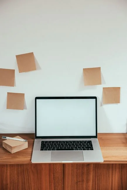 A bright desk setup featuring a design book, laptop, and creative tools, ideal for inspiration.